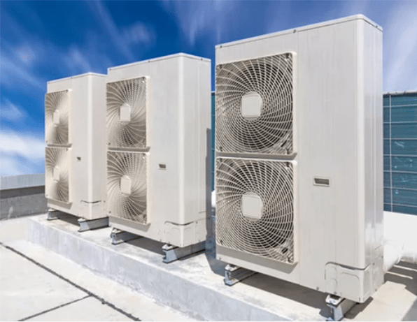 Condenser units on roof of industrial plant building with sky background